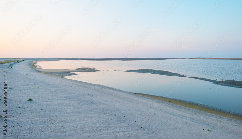 Artificial island under construction in a lake at sunset in summer