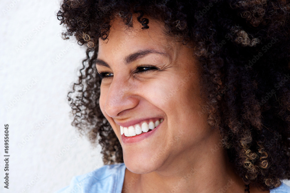 Side portrait of laughing woman with curly hair on white background Side portrait of laughing woman with curly hair on white background