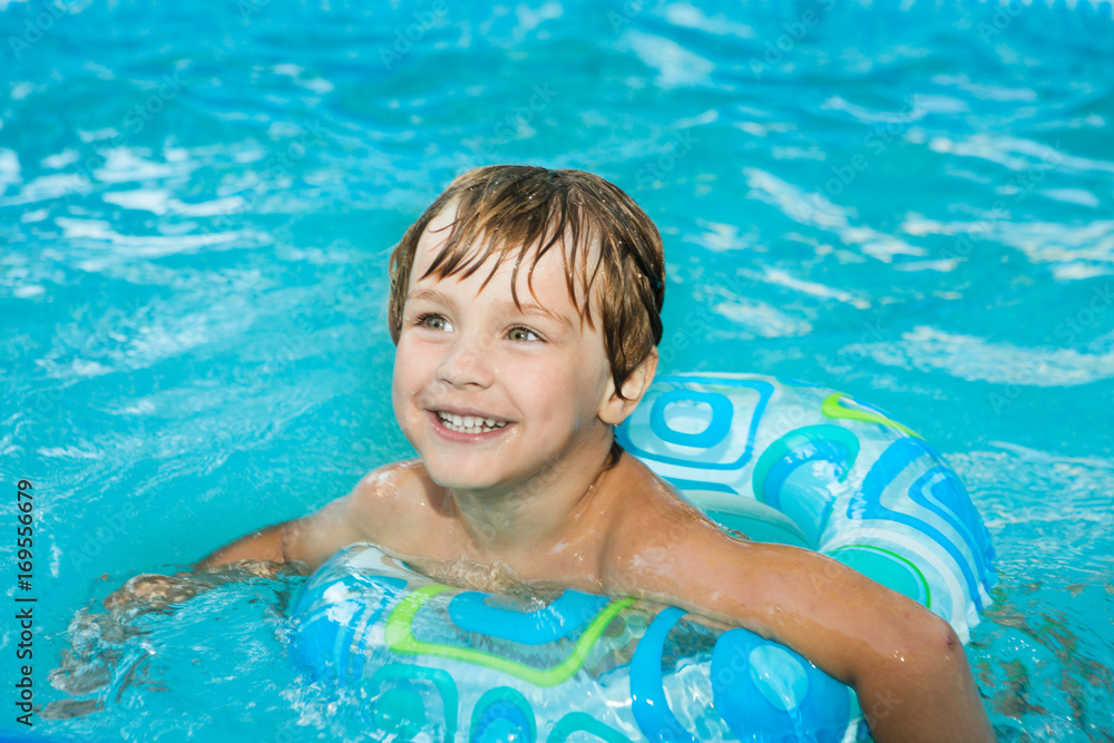 Little boy swimming in the pool with rubber ring, having fun in swimming pool. Little boy swimming in the pool with rubber ring, having fun in swimming pool.
