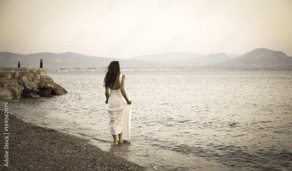Girl standing on the beach with white dress retro photo