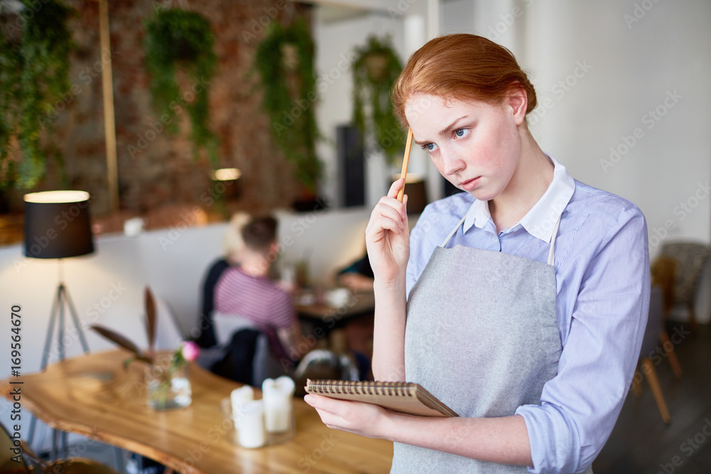 Young waitress trying to remember the latest client order Young waitress trying to remember the latest client order