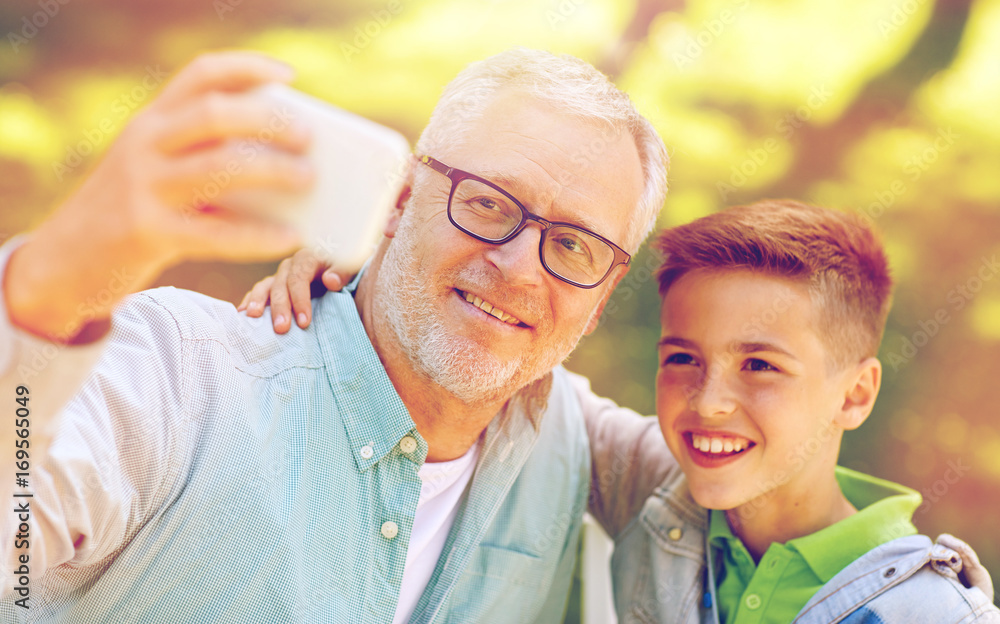 old man and boy taking selfie by smartphone