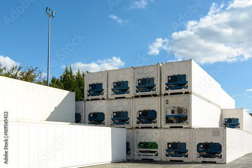 Dozens of immaculate white refrigerated cargo containers stacked in an intermodal terminal.