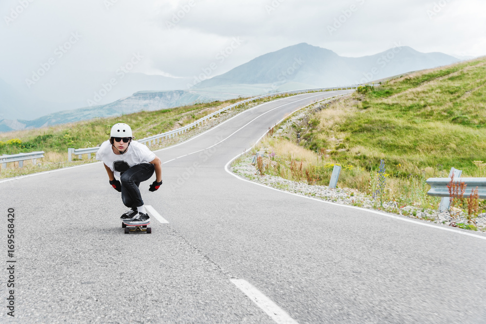 A young guy in helmet is riding on a country road at high speed in the rain A young guy in helmet is riding on a country road at high speed in the rain