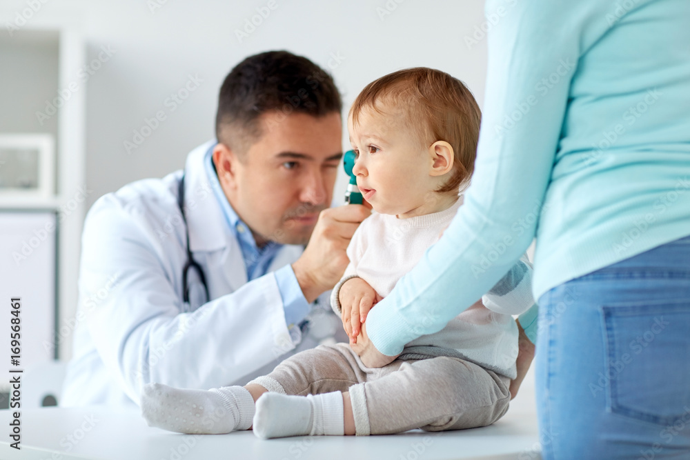 Obraz premium doctor checking baby ear with otoscope at clinic
