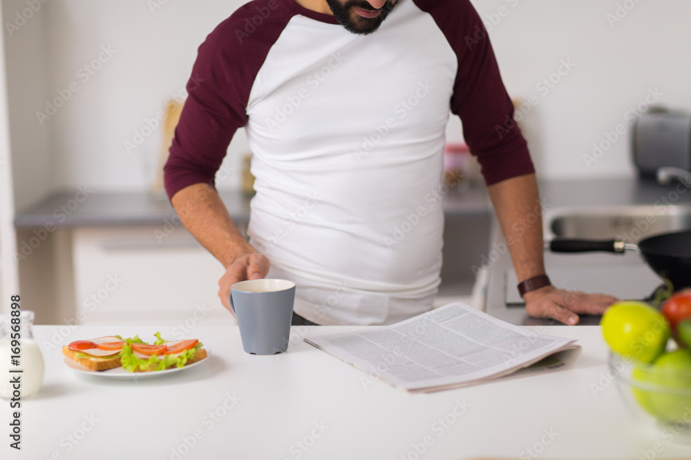 man reading newspaper and eating at home kitchen man reading newspaper and eating at home kitchen