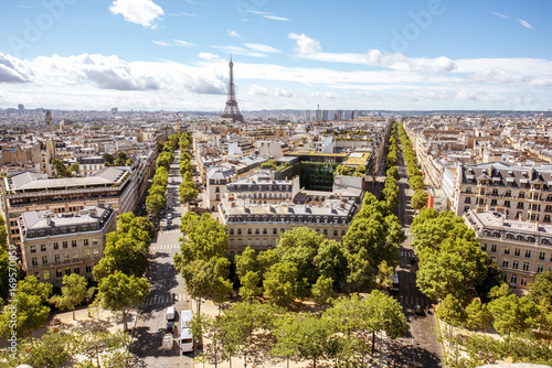 Aerial wide angle cityscape view on the beautiful buildings and avenues with Eiffel tower on the background during the sunny day in Paris © rh2010