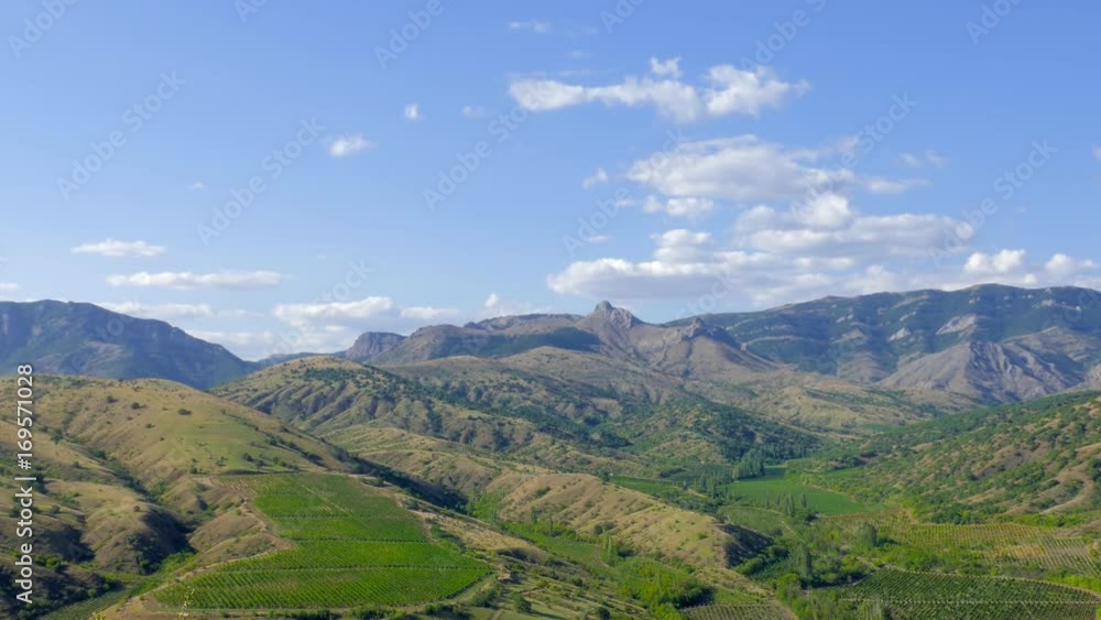Blue sky with white clouds above mountain slopes, time lapse / Blue sky with white clouds above the mountain slopes with vineyards, time lapse Blue sky with white clouds above mountain slopes, time lapse / Blue sky with white clouds above the mountain slopes with vineyards, time lapse