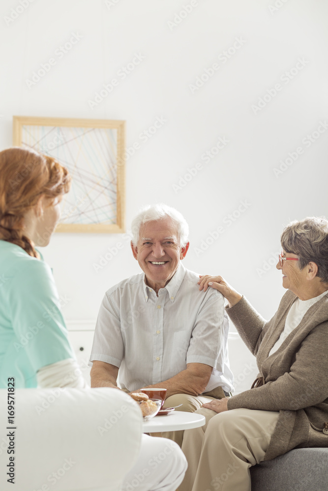 Obraz premium Smiling senior sitting next to wife