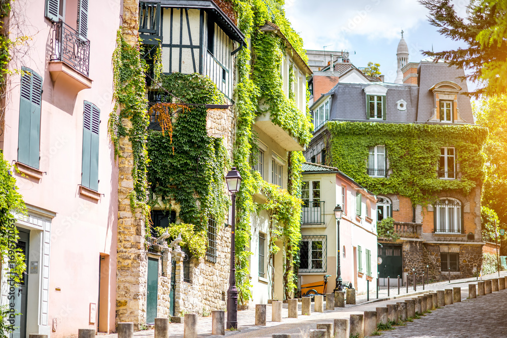 Naklejka premium Pejzaż miejski widok na pięknej ulicie z zielonymi budynkami na Monmartre wzgórzu w Paryż