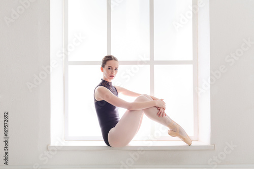 Beautiful ballerina near huge window with copy space