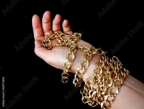 golden chain in hand, black background