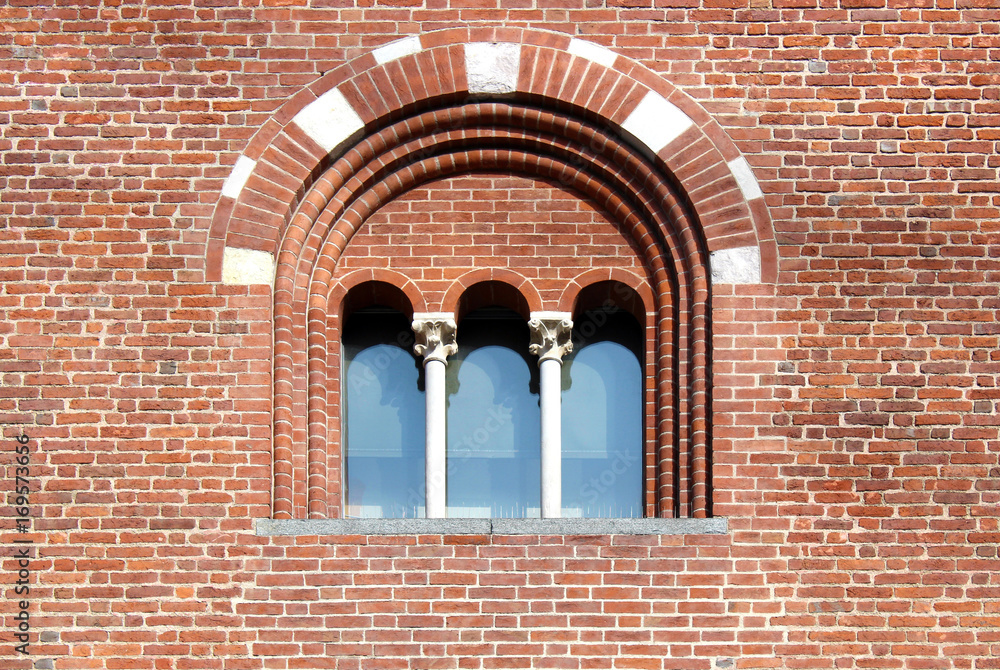 Mullioned window with three lights on a brick wall Mullioned window with three lights on a brick wall