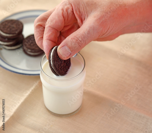 Dunking chocolate cookie in milk