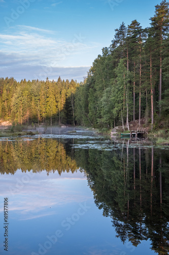 Tranquil morning view with pier and lake at early morning in Nuuksio National Park, Finland