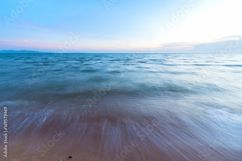 Soft waves on the sand at sunset,The beach is blue sea at sunset.