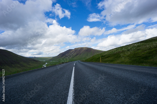 Iceland - Street curve in majestic icelandic landscape with high green mountains