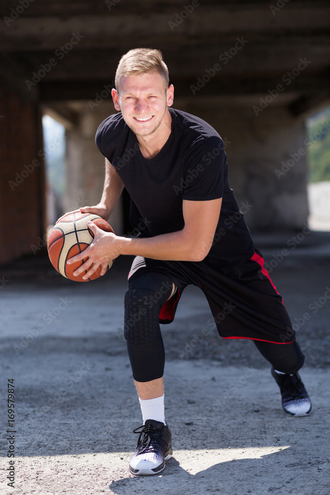 Good looking tall blonde male holding basket ball ready for crossover  dribble Stock Photo