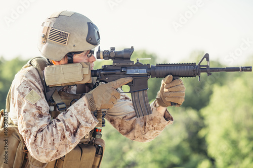 Army soldier in Protective Combat Uniform holding Special Operations Forces Combat Assault Rifle photo