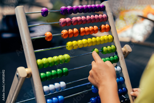 Educational colorful wooden abacus beads on table background. School arithmetic symbol, calculating thinking concept, closeup photography photo