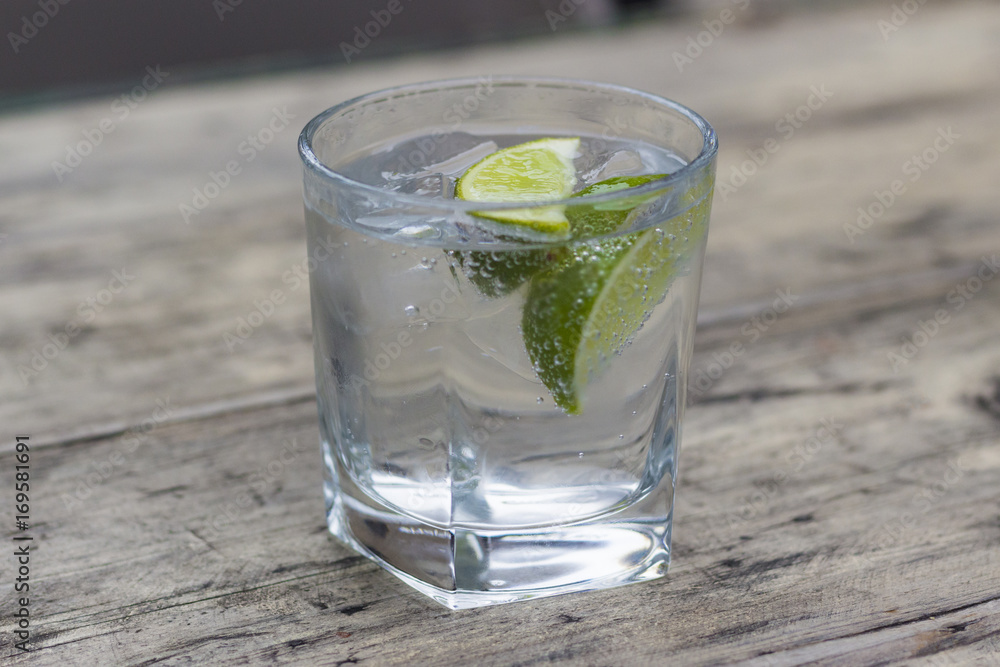 Gin and tonic with slice of lime in a glass Gin and tonic with slice of lime in a glass