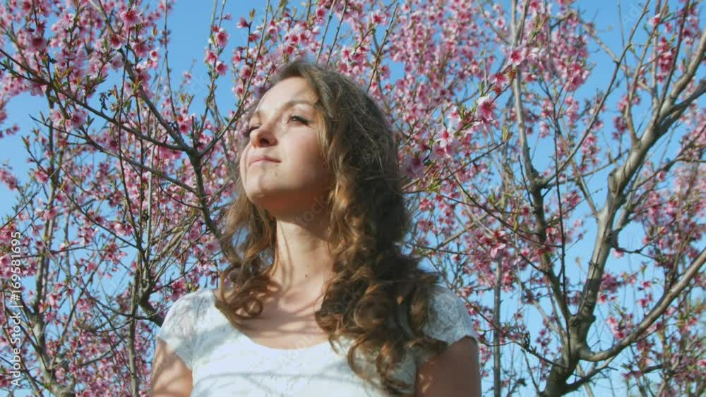 Portrait of the beautiful young woman against the background of the flowering tree Portrait of the beautiful young woman against the background of the flowering tree