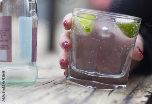 Glass of gin and onic in a womans hand photo