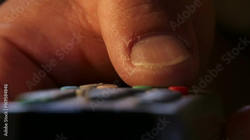 Finger pressing remote control, zapping & changing Tv channels photo