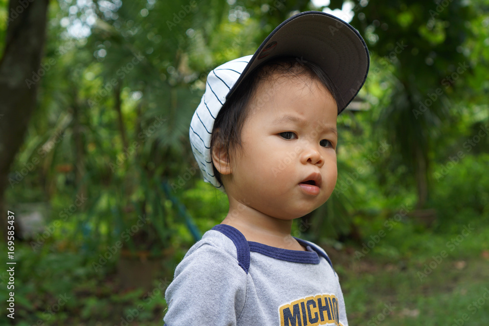 Attractive Asian toddler girl but look like toddler boy with white gap and grey body suit walk around garden with natural motion Attractive Asian toddler girl but look like toddler boy with white gap and grey body suit walk around garden with natural motion