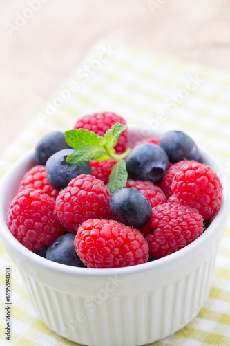 Oatmeal porridge in bowl with berries raspberries and blackberries.
