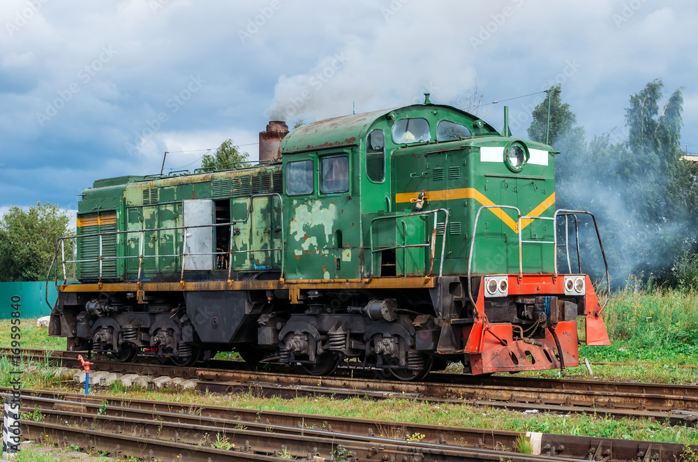 Naklejka premium Green shunting locomotive on railway tracks