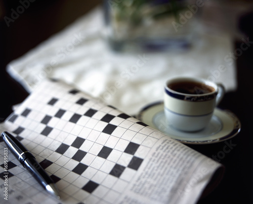 crossword puzzle with pen and black coffe