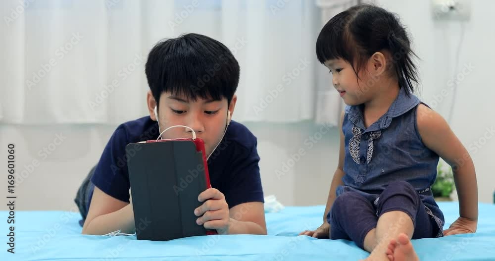 Asian sister and brother using a digital tablet together . Asian sister and brother using a digital tablet together .
