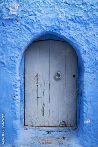 Detail of a wood door painted in blue in the beautiful town of Chefchaouen in Morocco, North Africa © Tiago Fernandez