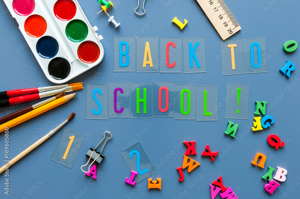 Back to school concept. Inscriptions on teacher or student workplace background with school supplies on blue table. Autumn time Back to school concept. Inscriptions on teacher or student workplace background with school supplies on blue table. Autumn time