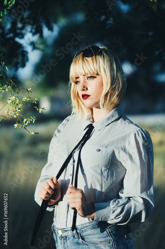 Girl in a shirt and tie with the nature photo