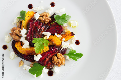 roasted beetrot, pampkin and walnuts with feta cheese decorated with parsley leafs and modena balsamic cream photo