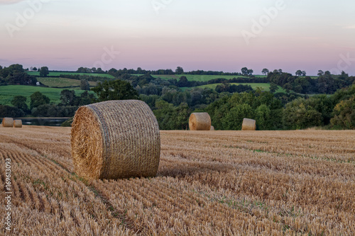 Late Summer sunset over field with hay bales