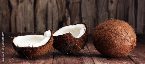 Ripe half cut coconut on a wooden background.