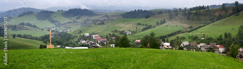 Summertime rural landscape banner, panorama - view at christian cross and the village Pucov, district Dolny Kubin, Slovakia
