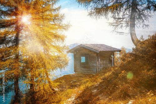 Herbstsonne scheint auf Holzhütte in den Bergen 