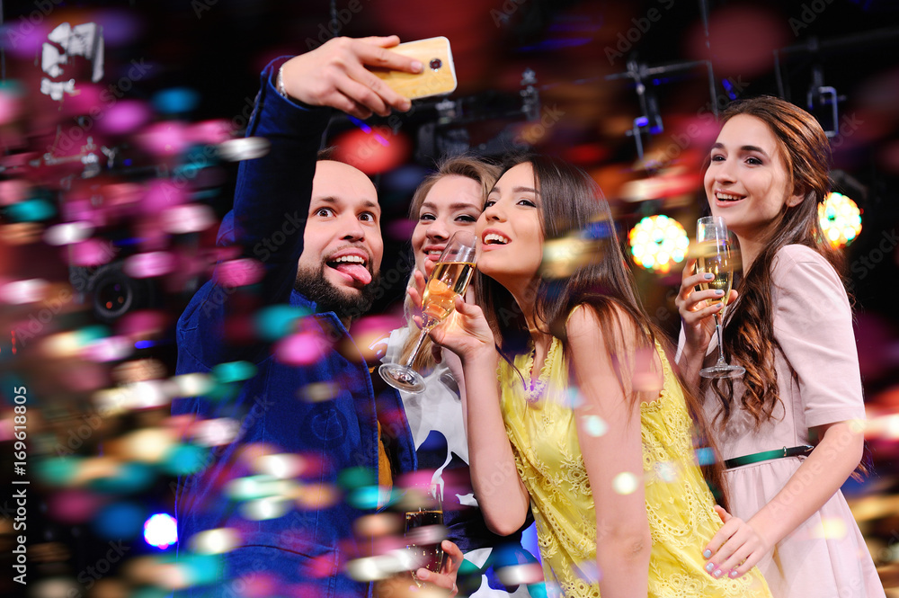 the cheerful company of best friends taking a selfie on your camera phone. To take a photo of yourself. Party, holiday, night club.