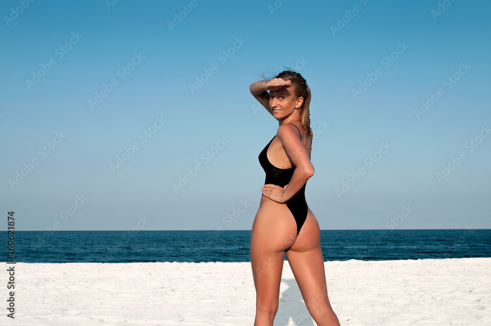 Beautiful woman in black swimsuit on the beach. Beautiful woman in black swimsuit on the beach.