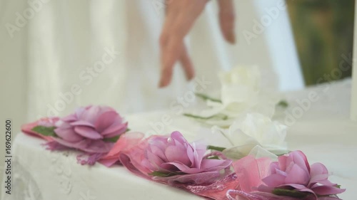 sposa accarezza fiori su di un tavolo della festa photo
