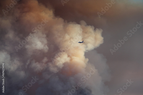 Airplane flies into the smoke of a huge wildfire photo