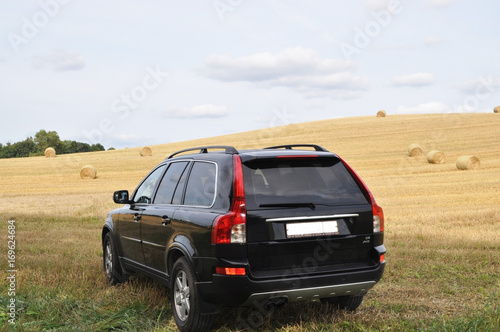 Sunday went with family to the countryside. Our black car is very looked at the background of the field. photo