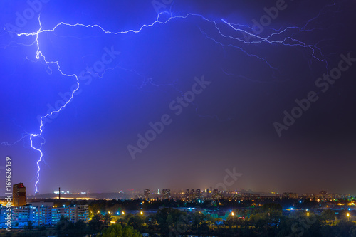 Lightning over the city at the summer storm. Dramatic  breathtaking atmospheric natural phenomenon.