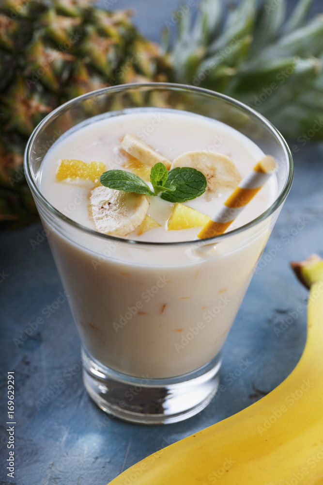 Glass of yogurt with pieces of banana and pineapple, close-up Glass of yogurt with pieces of banana and pineapple, close-up