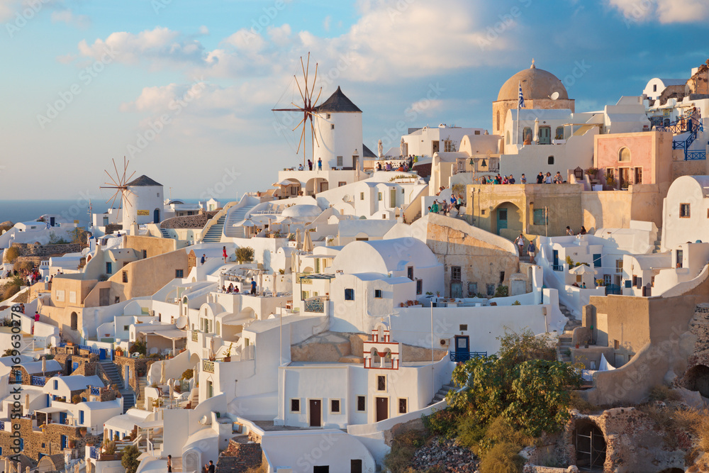 SANTORINI, GREECE - OCTOBER 4, 2015: The look to part of Oia with the windmills in evening light.