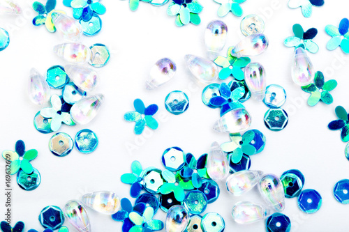 Abstract Background - close up of blue, green silver sequins on white background